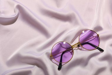 Açık renk kumaş arka planda leylak güneş gözlüğü