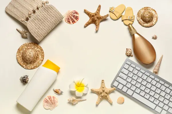 Beyaz arkaplanda güneş kremi ve plaj dekoru olan bilgisayar klavyesinden yapılmış çerçeve