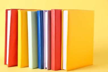 Sarı arkaplan üzerine renkli kitaplar dizisi