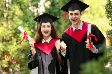 Dışarıda diploması olan birkaç mutlu mezun öğrenci.
