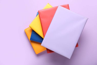 Leylak arkaplanı üzerine birçok renkli kitap