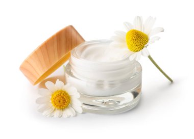 Beyaz arka planda izole edilmiş bir kavanoz doğal krema ve papatya çiçeği.