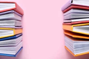Pembe arkaplan üzerine renkli kitapları aç