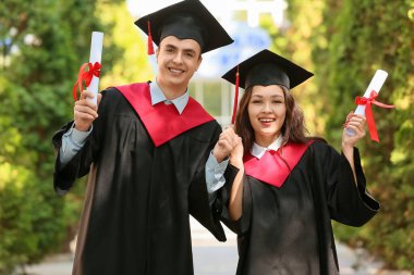 Dışarıda diploması olan birkaç mutlu mezun öğrenci.