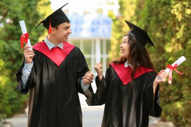Dışarıda diploması olan birkaç mutlu mezun öğrenci.