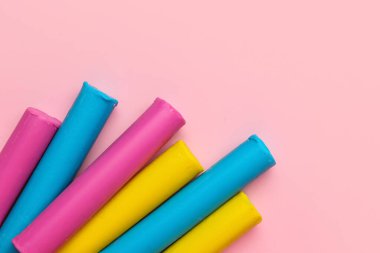 Pembe arka planda renkli plastikler, yakın plan.