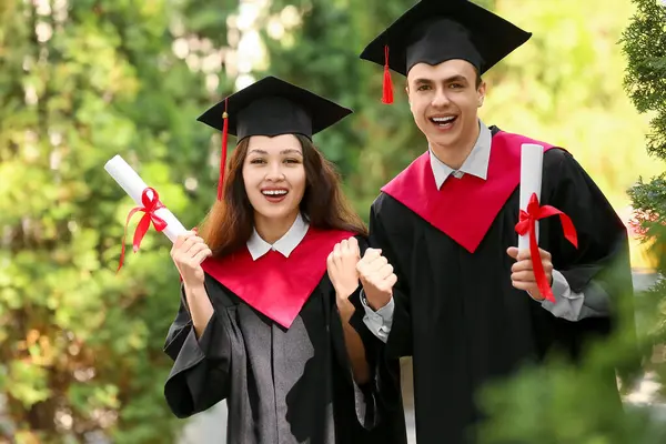 Dışarıda diploması olan birkaç mutlu mezun öğrenci.