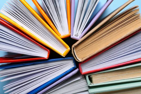 Mavi arkaplan üzerine birçok renkli kitap, yakın plan