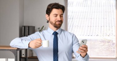 Ofiste cep telefonu kullanan bir iş adamı.