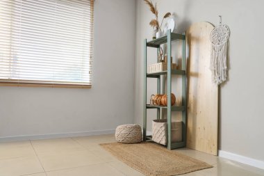 İçinde raf ünitesi, puf ve balkabağı olan bir oda.