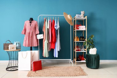 Manken, giysi askılığı ve raf ünitesi olan soyunma odasının içinde.