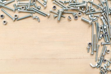 Farklı musluk cıvataları ve ahşap arka planda krom fındıklardan yapılmış çerçeve