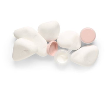 Beyaz arkaplanda kozmetik ürünler ve spa taşları içeren kompozisyon