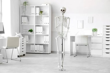 Masada insan iskeleti modeli ve modern dizüstü bilgisayarı olan hafif bir hastane.