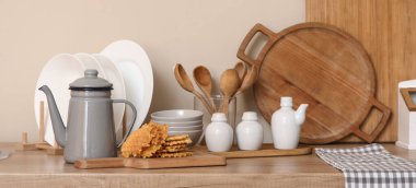 Mutfaktaki masada lezzetli waffle ve çatal bıçaklı çaydanlık.