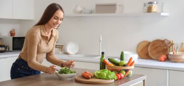 Genç bir kadın mutfakta sebze salatası yapıyor. Keto diyet kavramı