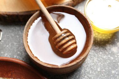 Gri arkaplanlı tatlı bal kasesi, yakın plan.
