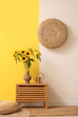 Çekmecede ayçiçekli vazo ve sulama kutusu var.