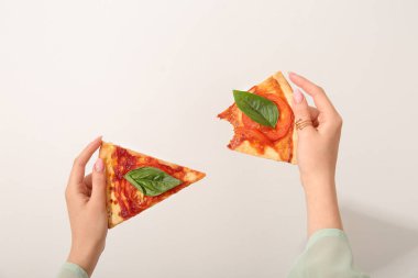 Woman holding slices of tasty pizza on white background