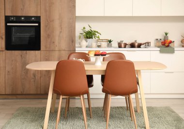 Ahşap yemek masası olan modern mutfağın içi.