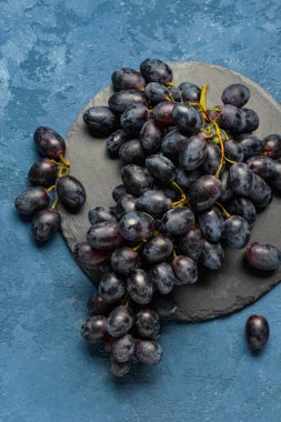 Mavi arka planda tatlı siyah üzümlü tahta