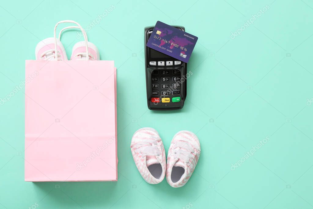 Composition with shopping bag, baby shoes and payment terminal on color background