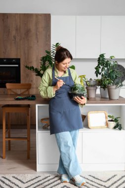 Mutfakta kürek ve floraryumu olan kadın bahçıvan.