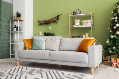 Kanepenin üzerinde parlayan Noel ışıkları olan modern oturma odasının şık bir iç mekanı.