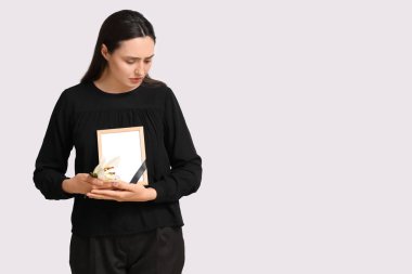 Nilüfer çiçeği ve beyaz arka planda fotoğraf çerçevesi olan genç bir kadın.