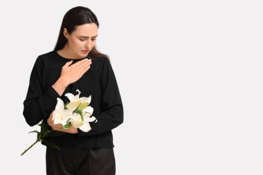 Beyaz arka planda zambak çiçekleri olan genç bir kadın.