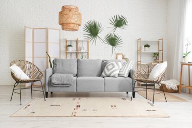 Oturma odasının içinde kanepe, koltuk ve katlanır ekran var.