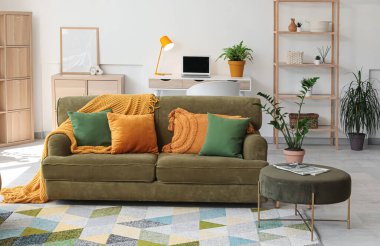 Modern oturma odasının içinde şık bir kanepe ve bitkiler var.