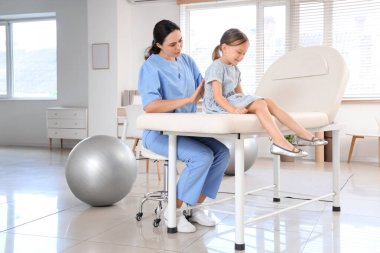 Klinikte küçük bir hastayla çalışan kadın osteopat.