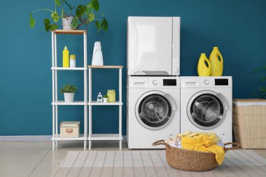 Çamaşır makinesi, kurutma makinesi ve sepetleri olan bir çamaşırhane.
