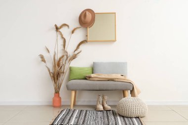 Salonun içinde yumuşak bank, ayna ve otlar var.