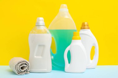 Renkli arka planda havlusu olan deterjan şişeleri