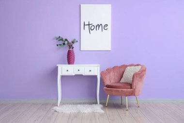 Odada mor duvarın yanındaki klozette çiçek vazosu olan koltuklar.