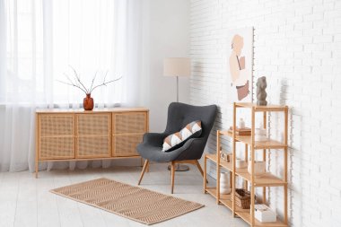 Odanın içinde ahşap raf ünitesi, koltuk ve tuvalet var.