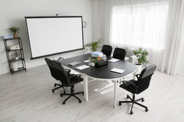 Modern ofiste masa, raf ve projektör ekranlı konferans salonunun içi