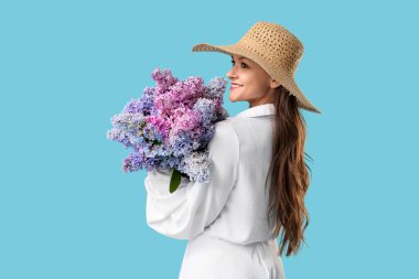 Beautiful young woman with bouquet of blooming lilac flowers on blue background