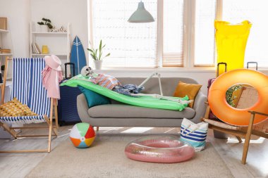 Oturma odasındaki kanepede plaj aksesuarlarıyla insan iskeleti.