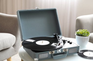 Oturma odasındaki masada vinil diski olan kayıt çalar