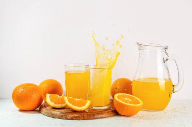 Sürahi ve beyaz arka planda taze portakal suyu.