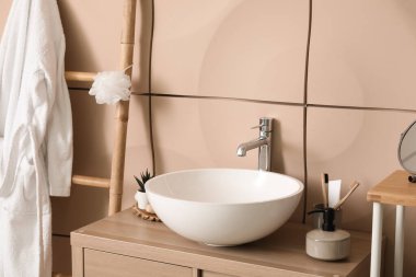 Banyo aksesuarlı lavabo lavabosu banyodaki masada.