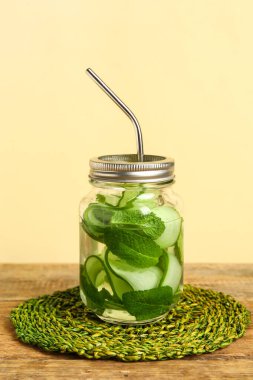 Ahşap masada salatalık dilimleri ile doldurulmuş Mason kavanozu.