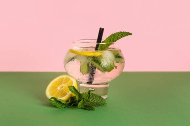 Bir bardak salatalıklı limonata ve renkli arkaplanda nane şekeri.