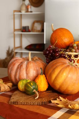 Modern mutfakta kabaklı, sonbahar yapraklı ve üzümlü bir masa.