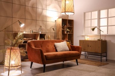 Parlayan lambalar ve gece kanepesi olan şık bir oturma odası.