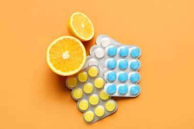 Boğaz ağrısı için ilaç. Arka planda limon ve turuncu.