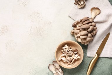 Ahşap kase ve arkaplanda taze istiridye mantarı.